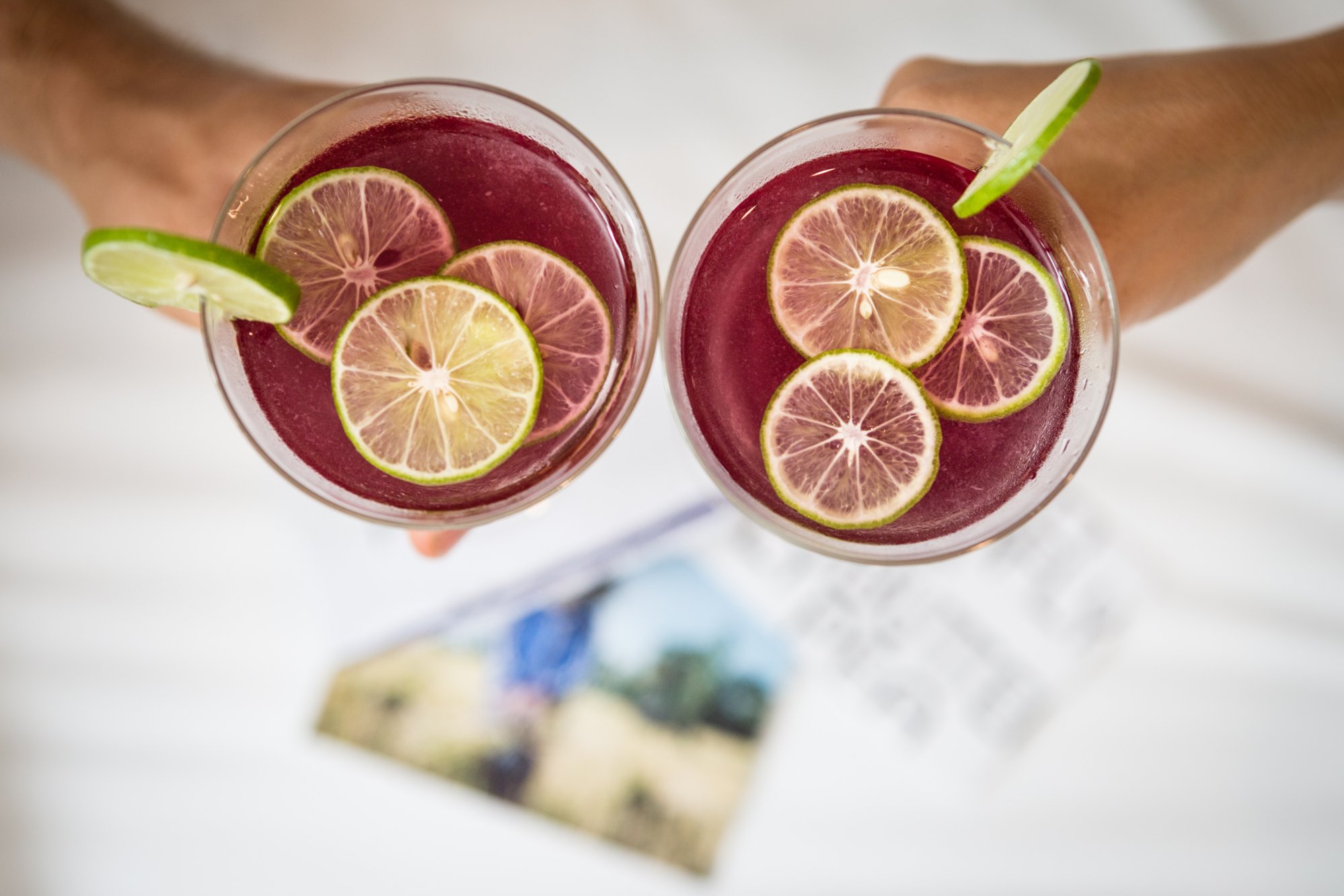 two people cheering with their two butterfly pea cocktails