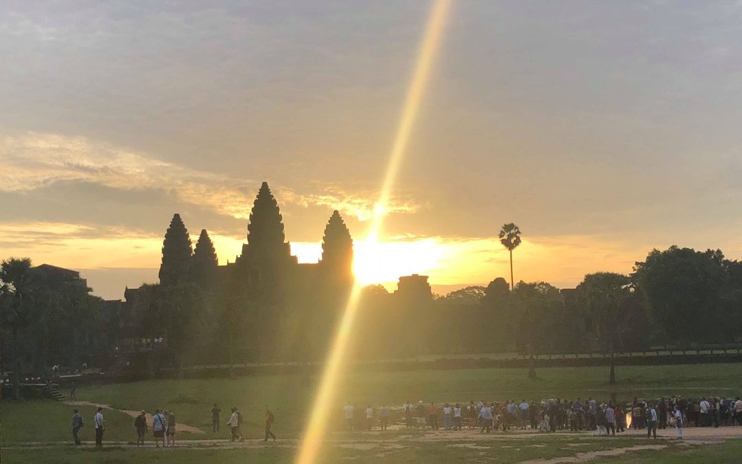 sun rising over angkor temples, lighting up the sky