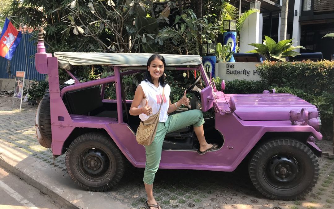 Sreyneang posing by her lavender colored army jeep at the Butterfly Pea Hotel